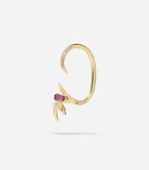 Bijou d'oreille doré inspiré de la forme d'une branche et orné d'une perle transparente rose et de petits strass roses.