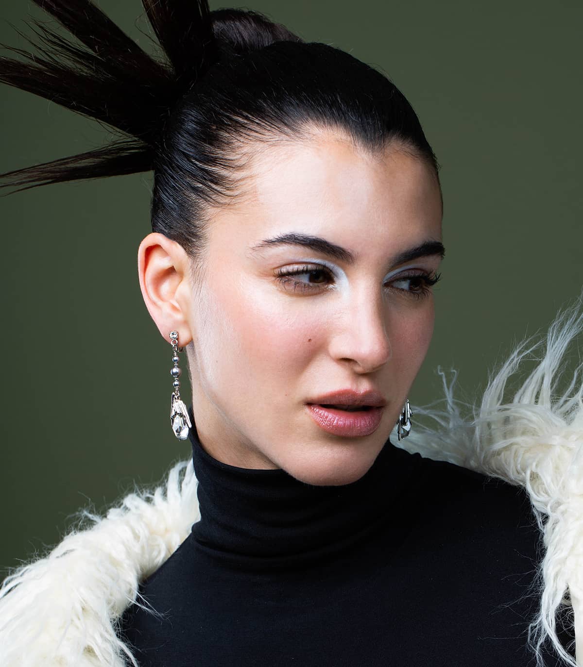 La mannequin porte les boucles d'oreilles cristal de roche argentées